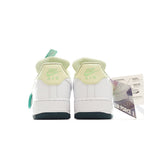White Nike Air Force 1 sneakers with green lace panels and teal heel trim