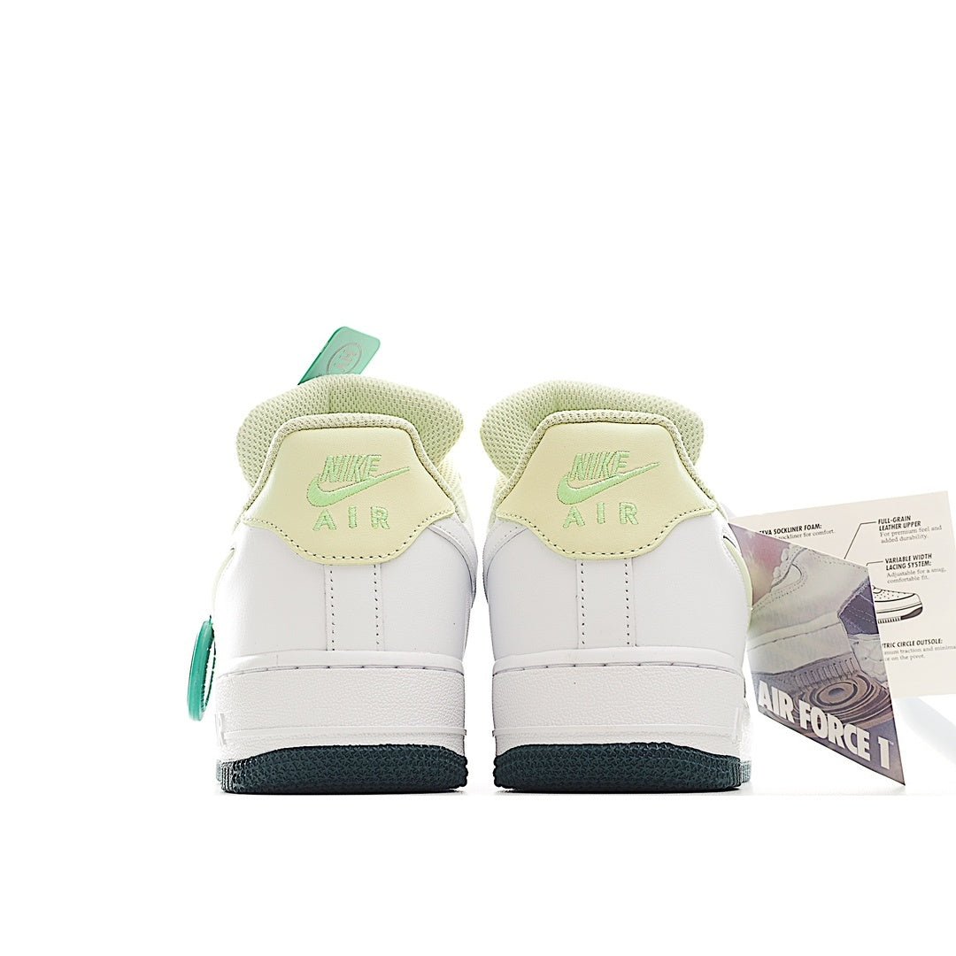 White Nike Air Force 1 sneakers with green lace panels and teal heel trim