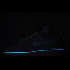 Dark navy Nike Air Force 1 sneakers with glowing blue stripe and neon green accents