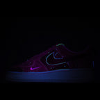 Dark purple low-top sneaker with neon blue swoosh and glow accents