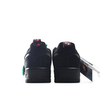 Black low-top sneaker heel view with red swoosh and teal accents