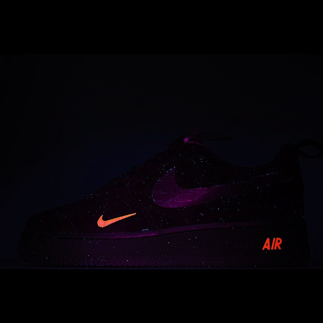 Dark low-top sneaker with red swoosh and AIR lettering under purple lighting