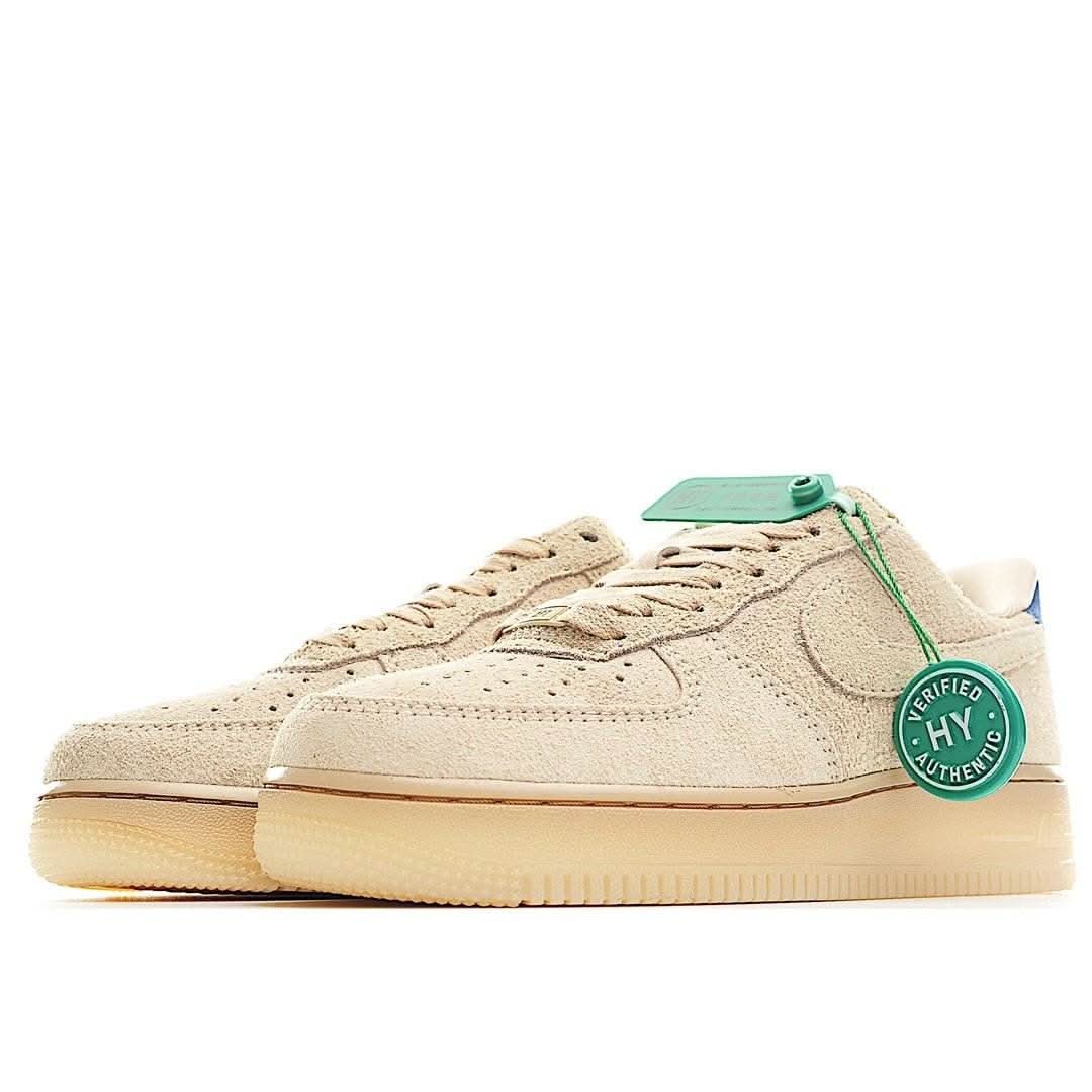 Beige suede low-top sneakers with blue accents, lace-up front, gum sole
