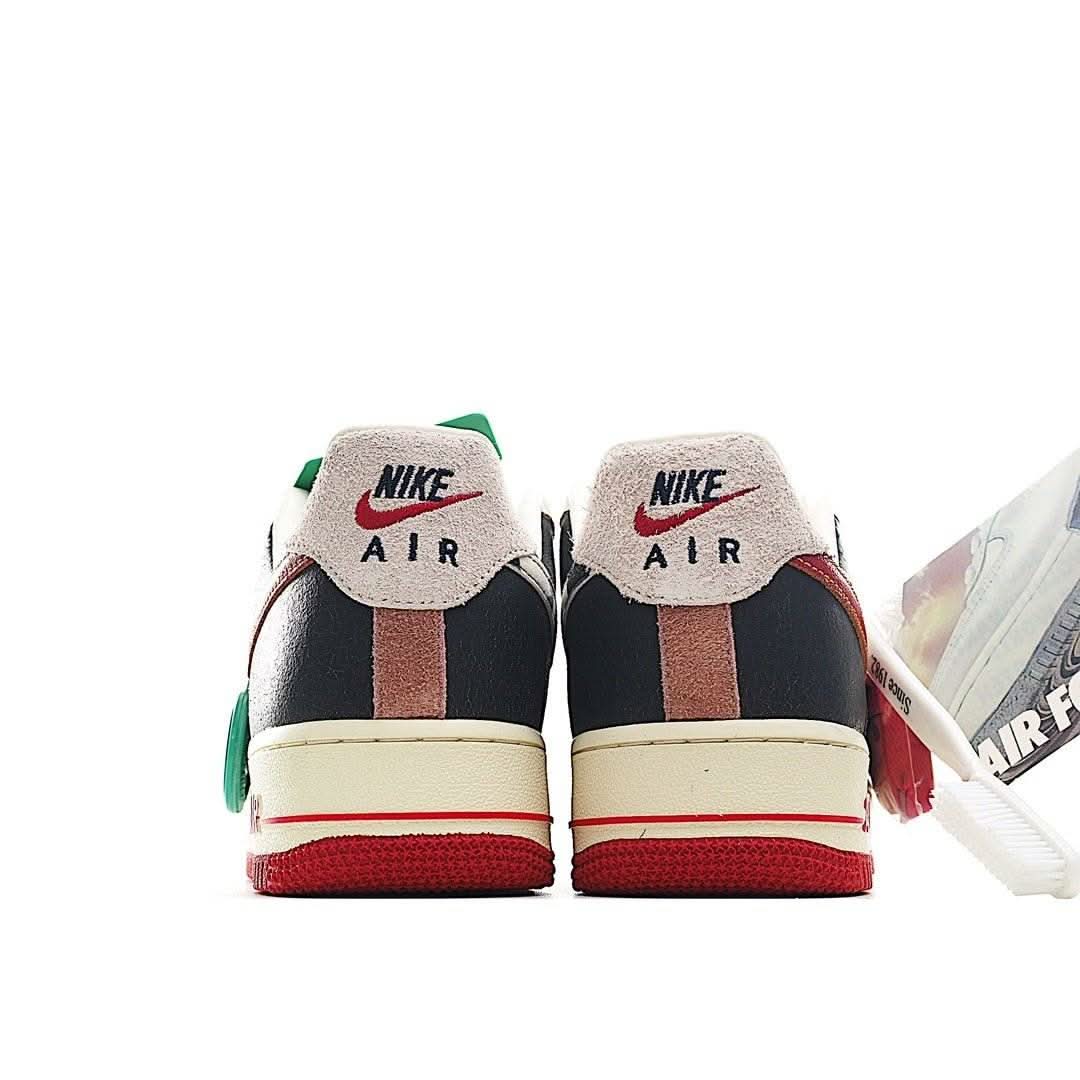 Back view of low-top sneakers with navy heel panels, green lace ties, and red-striped sole