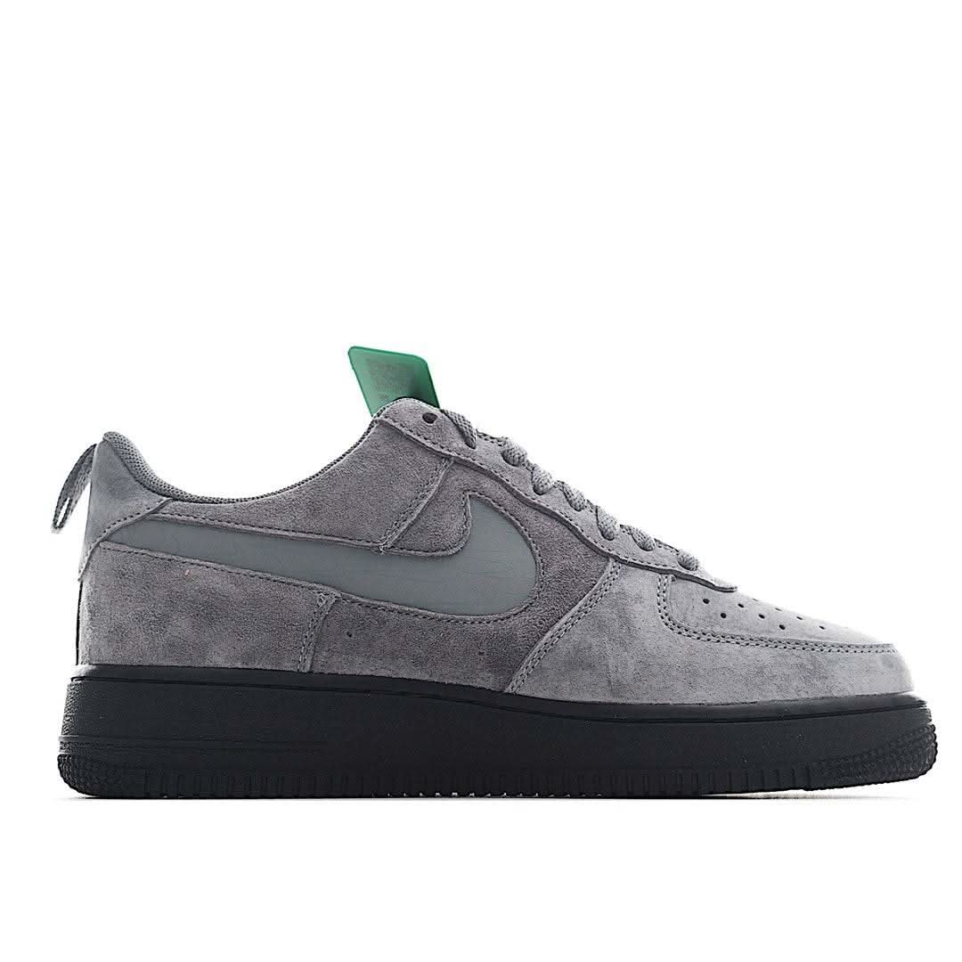 Grey suede low-top sneakers with green lace loop and black rubber sole