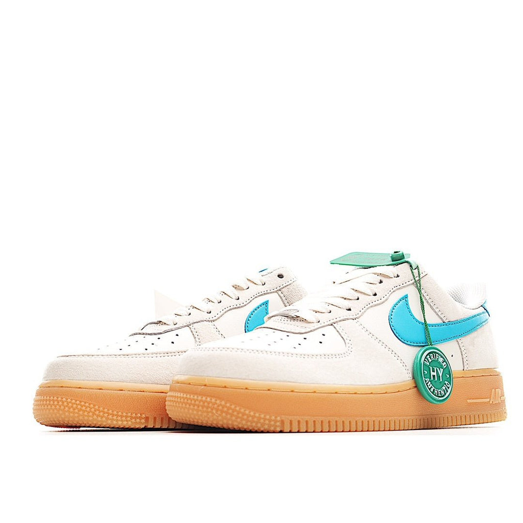 White low-top sneakers with teal swooshes and tan gum rubber sole