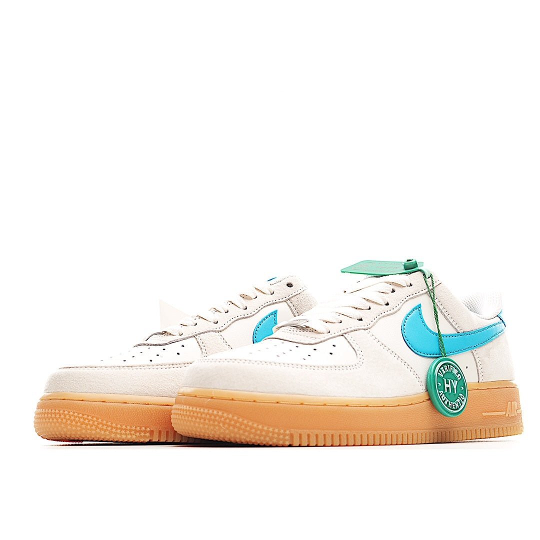 White low-top sneakers with teal swooshes and tan gum rubber sole