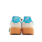 Pair of white sneakers with teal heel panels and tan gum outsoles