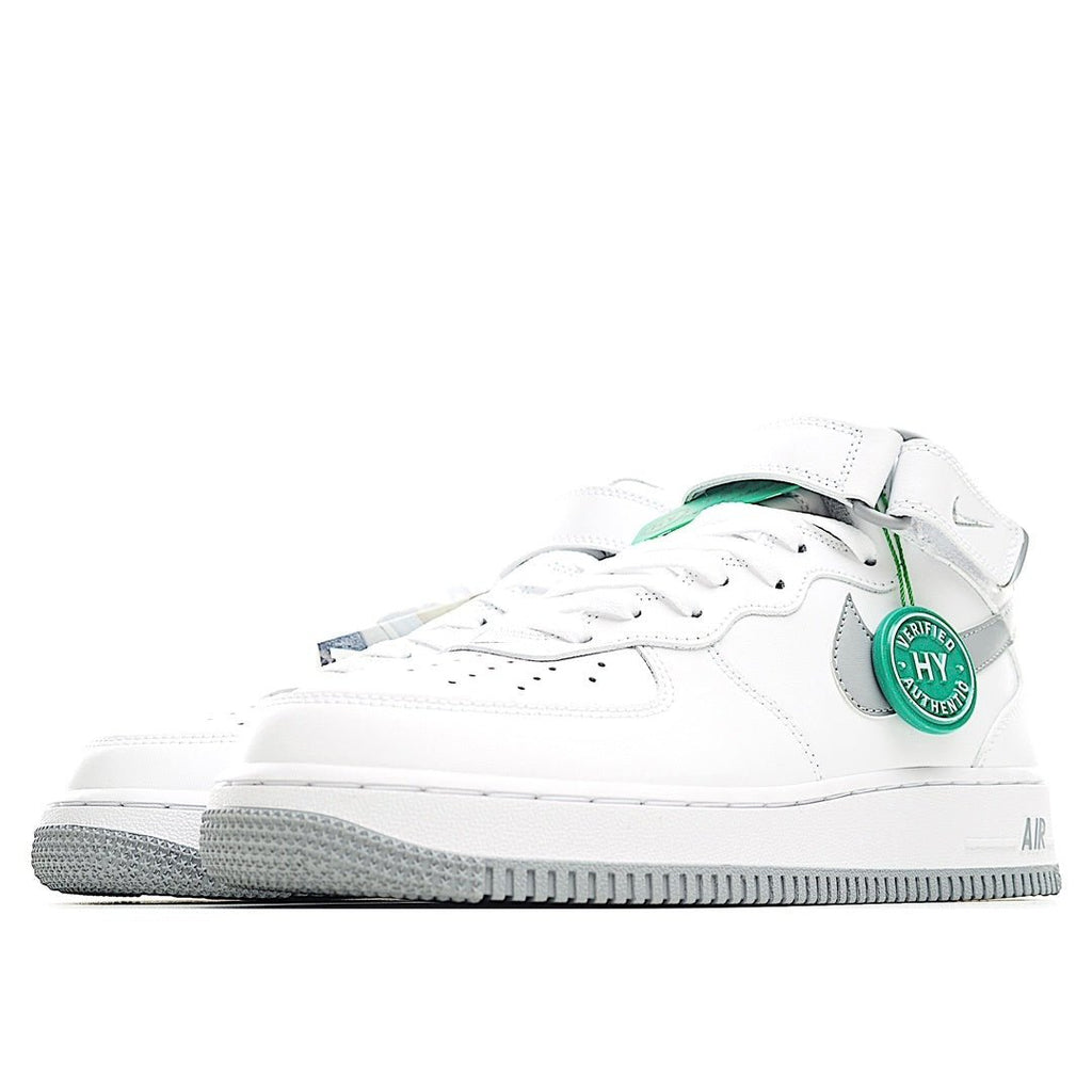 White low-top sneaker side view with gray stripe and green heel tab detail