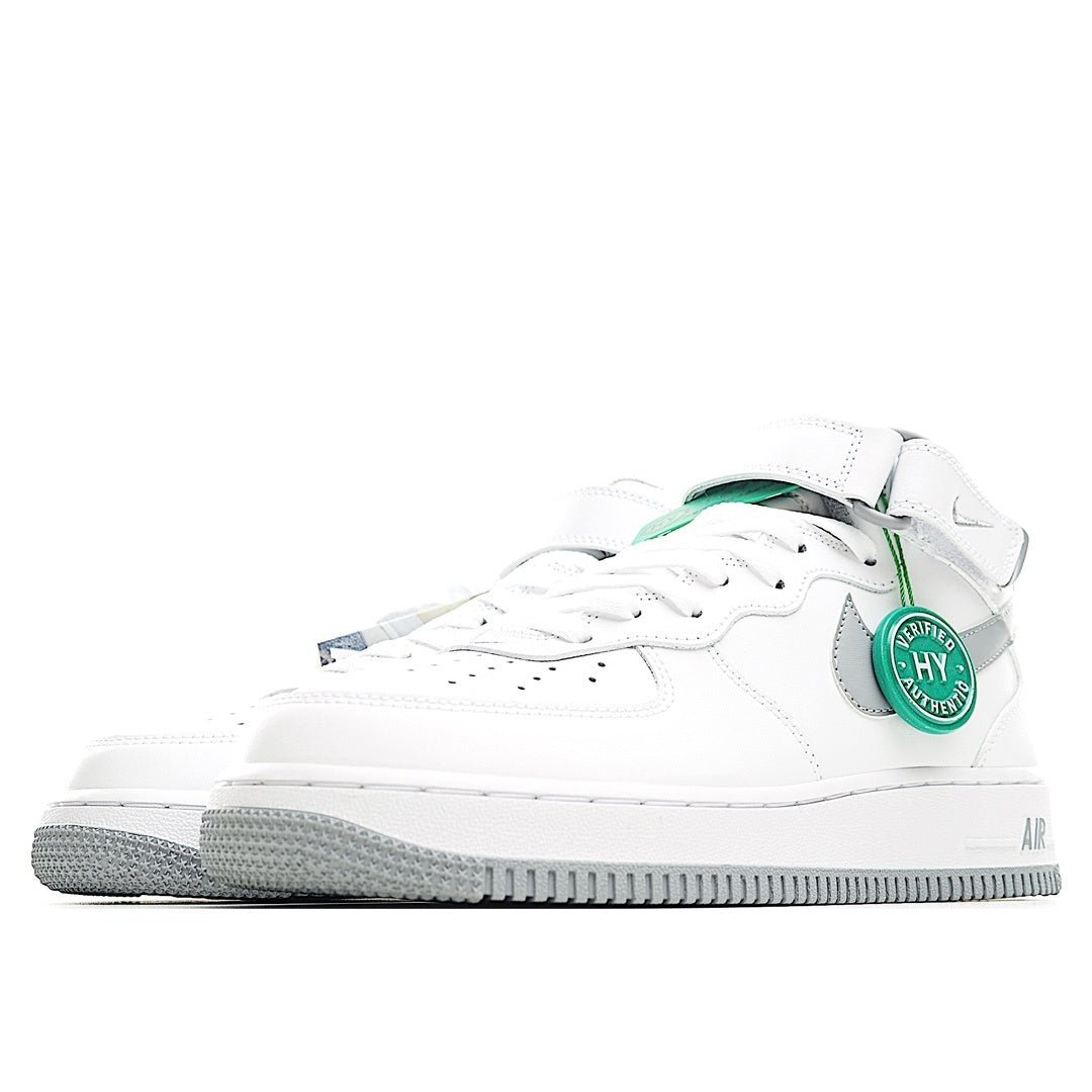 White low-top sneaker side view with gray stripe and green heel tab detail