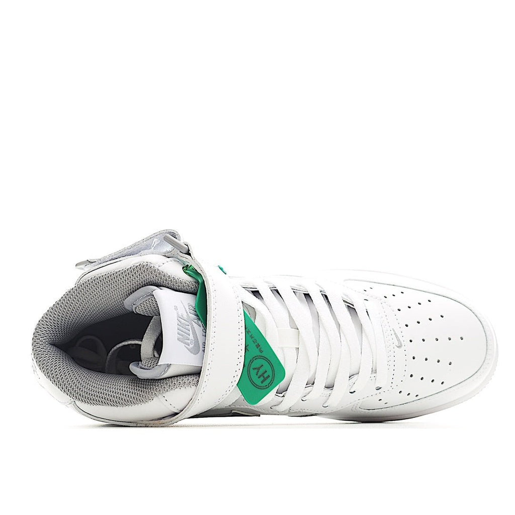 White sneaker with gray lining, green heel tab, and lace-up front