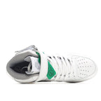 White sneaker with gray lining, green heel tab, and lace-up front