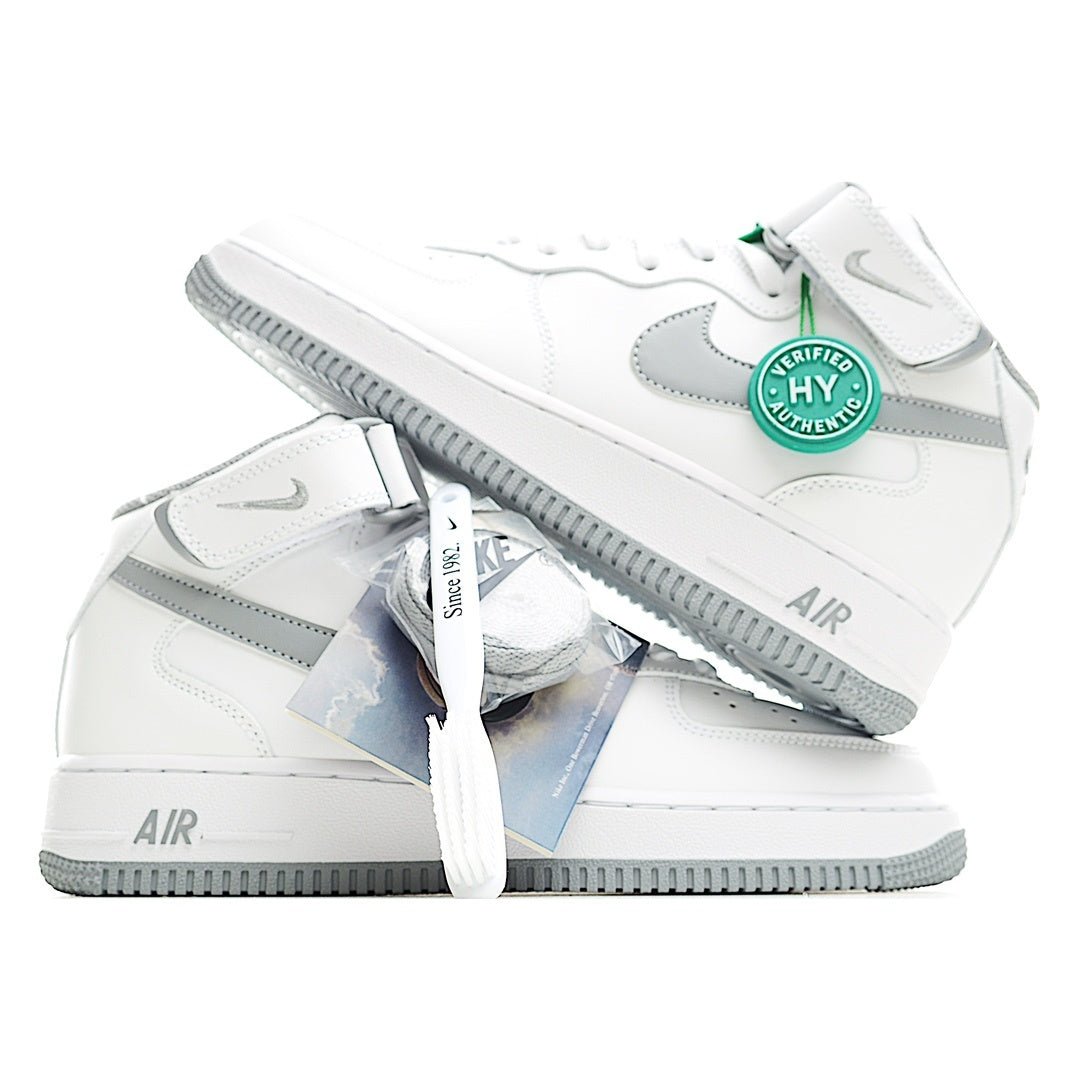 White sneaker pair angled view with gray side panels and green badge accent