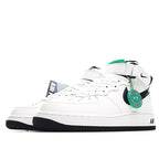 White low-top sneakers with black swoosh, green accent tag, and black outsole