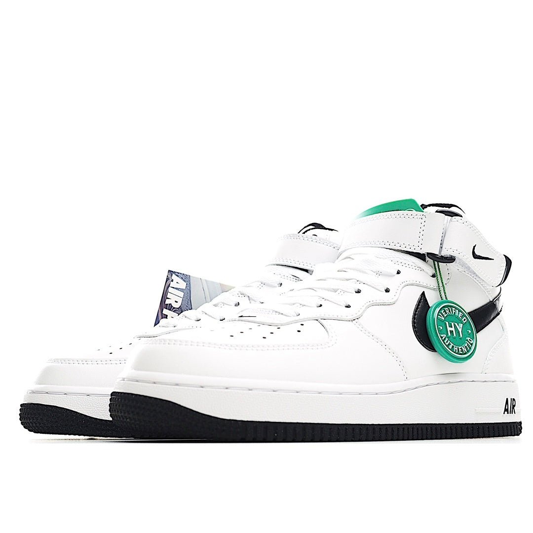 White low-top sneakers with black swoosh, green accent tag, and black outsole
