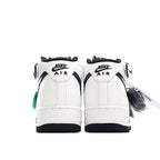 Pair of white high-top sneakers with black Nike Air text and green accents