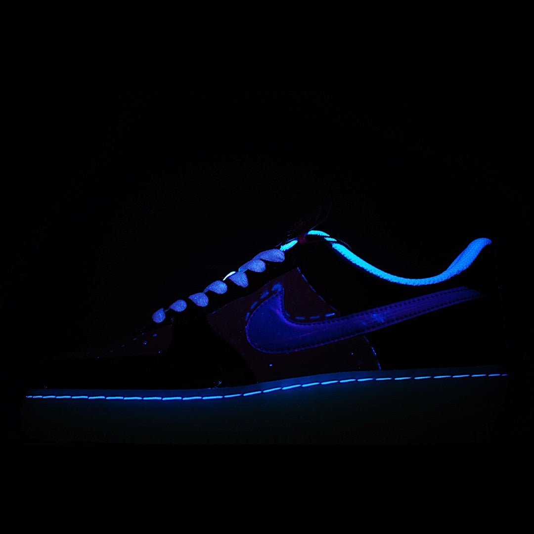 Low-top sneaker with dark upper, blue Swoosh, and glowing blue outsole edge