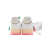 White low-top sneaker heel view with Nike Air logo, green heel tab, and pink sole