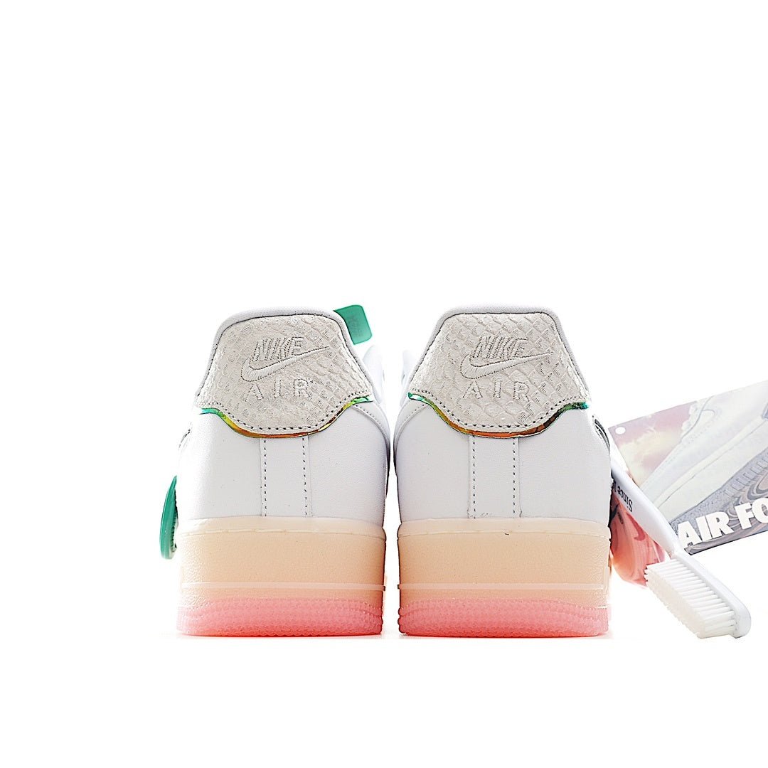 White low-top sneaker heel view with Nike Air logo, green heel tab, and pink sole