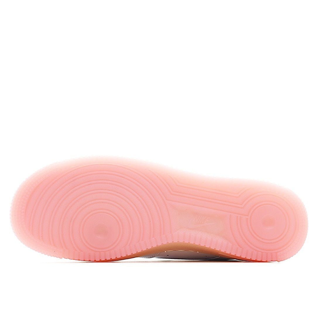 Pink outsole with tread pattern under a white low-top sneaker