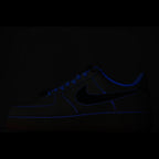 Dark blue low-top sneaker with Nike swoosh and blue laces on black background
