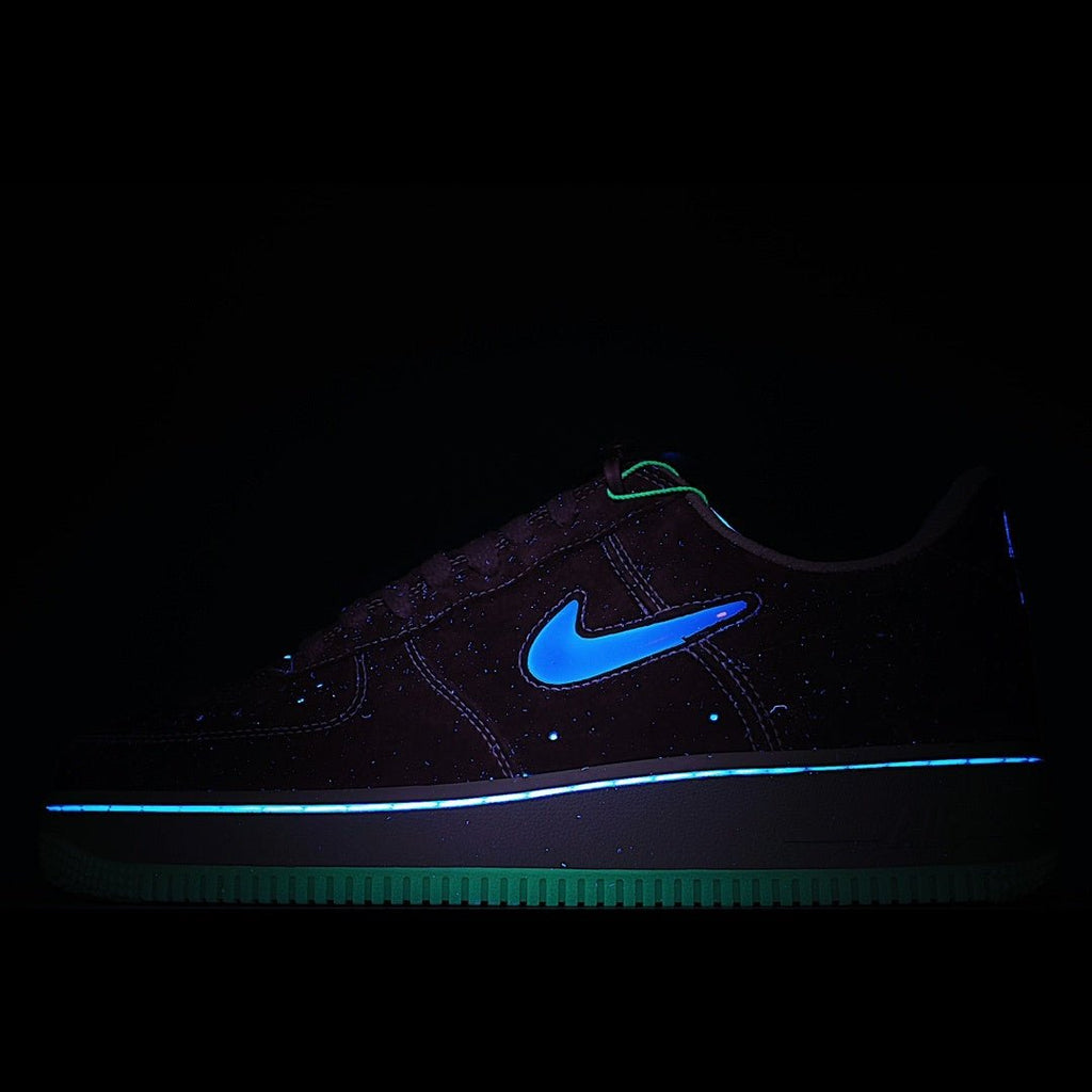 Dark Nike sneaker with neon blue swoosh and glowing outsole, low-top style