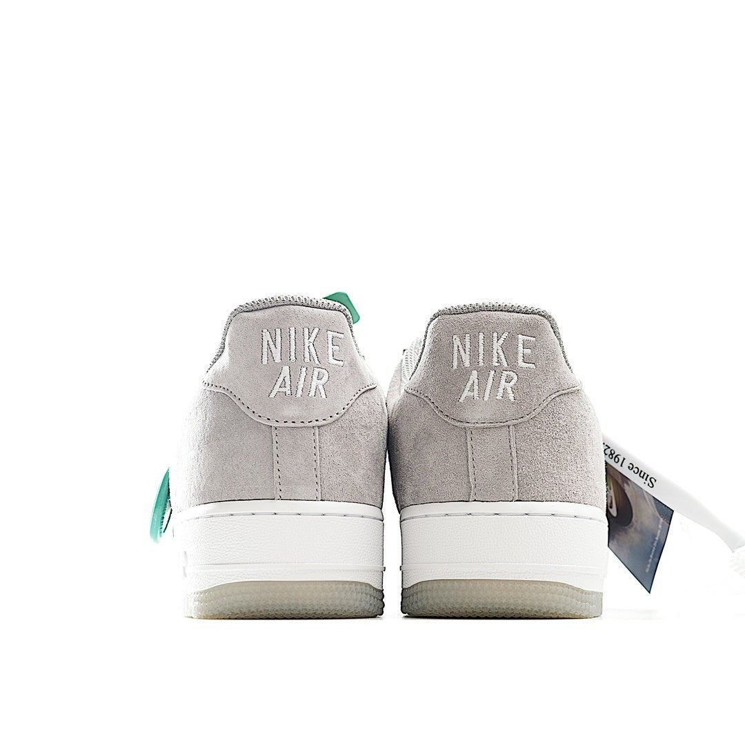 Light gray low-top sneakers with Nike Air branding on heel and green lace pull