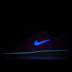Dark low-top sneakers with blue swoosh and blue light stripe along side