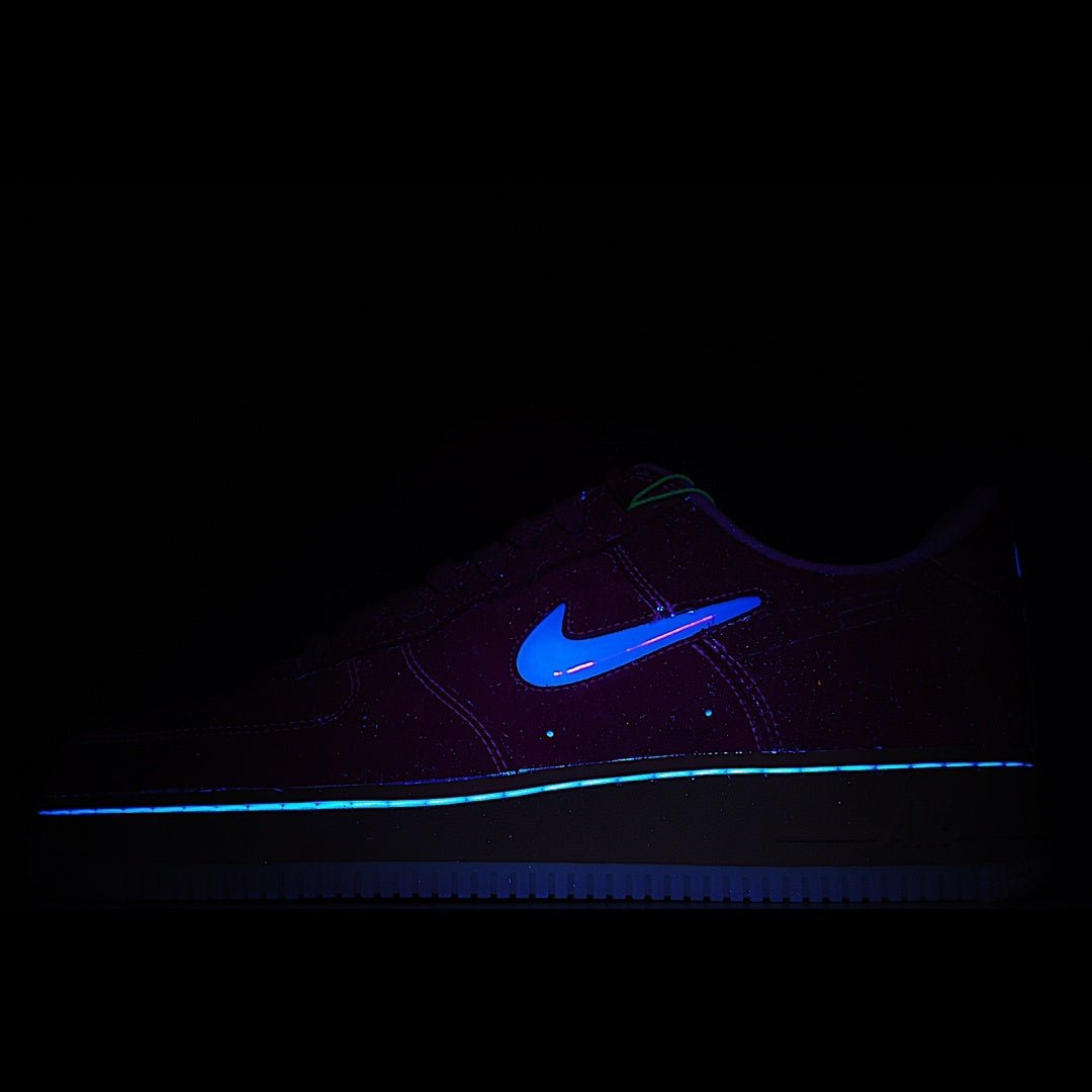 Dark low-top sneakers with blue swoosh and blue light stripe along side