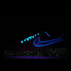 Low-top sneaker with blue swoosh and speckled midsole on a dark outsole