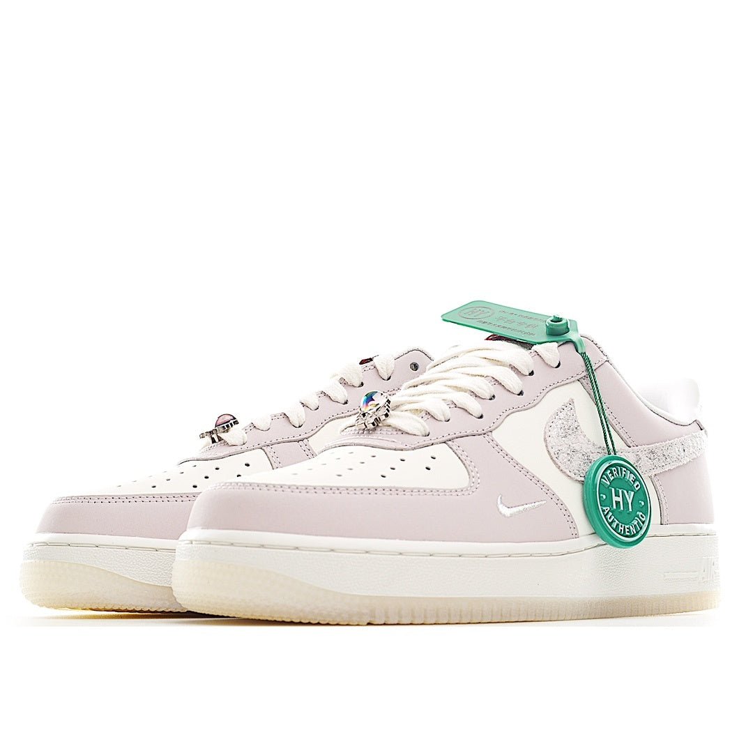 Low-top sneaker in pale pink and white with green lace accents and perforated toe.