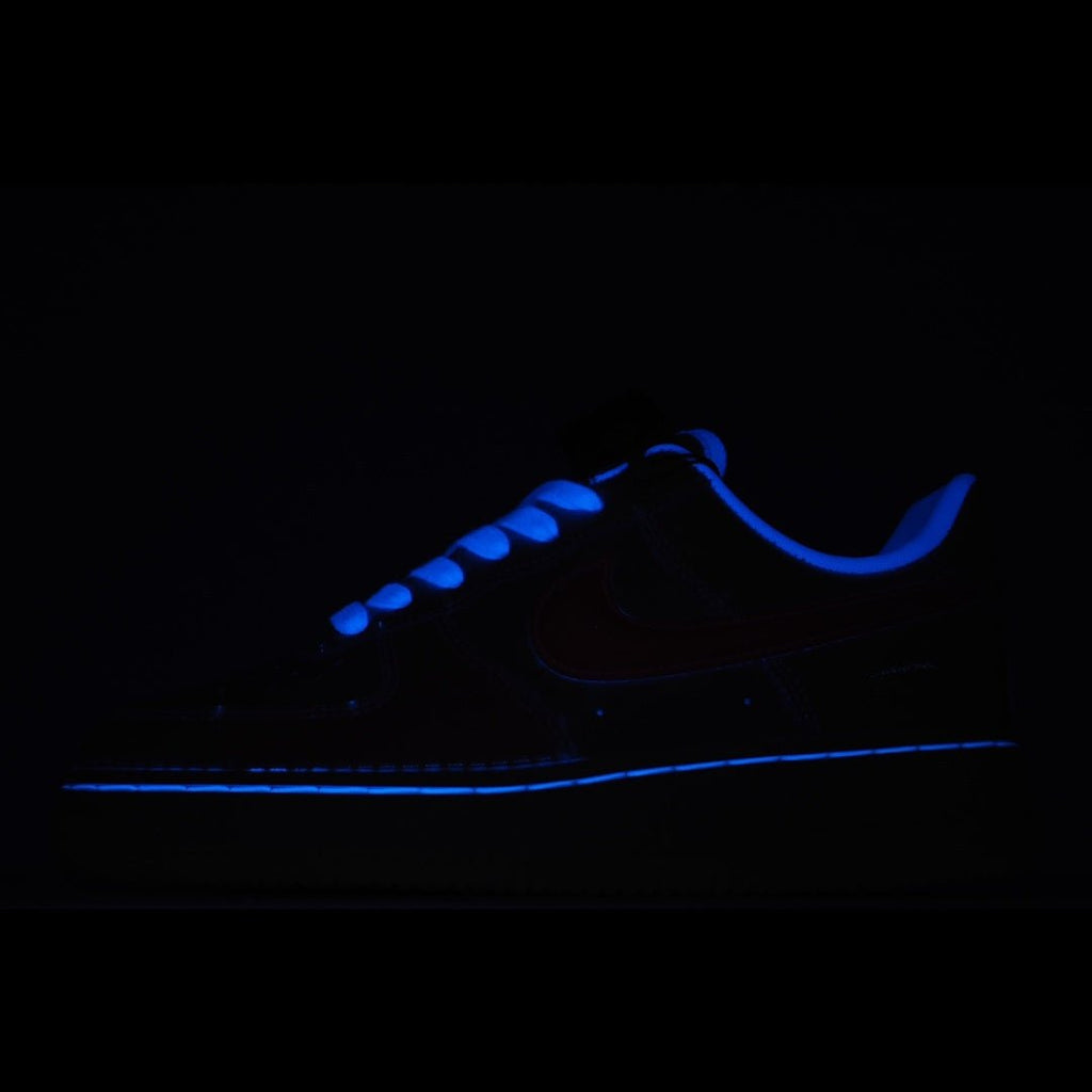 Low-top sneakers with blue glowing accents in dark lighting