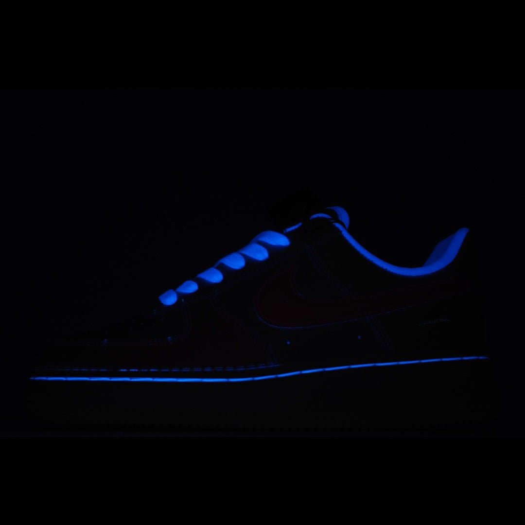 Low-top sneakers with blue glowing accents in dark lighting