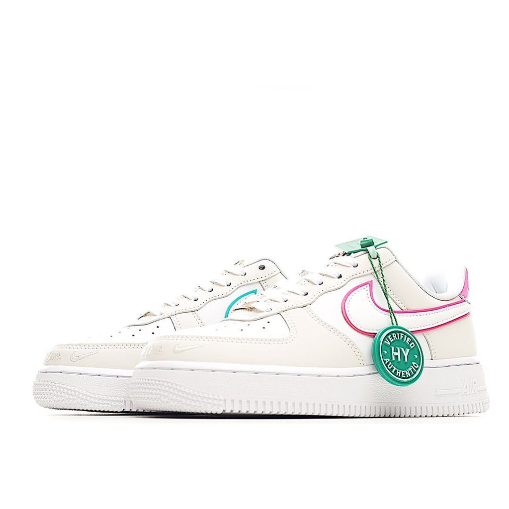 White low-top lace-up sneaker with teal heel tab and pink trim along the side