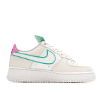 White low-top sneaker with teal swoosh and pink heel accent, lace-up