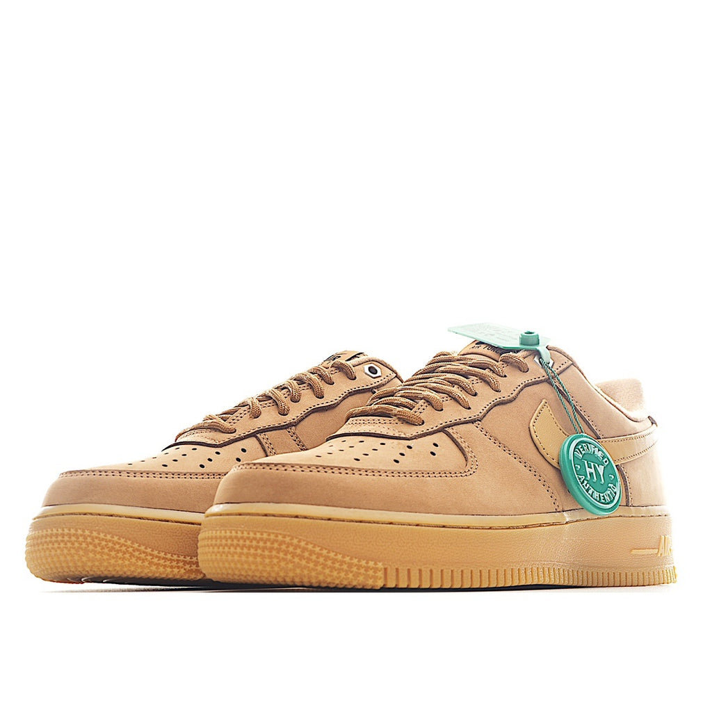 Pair of tan Nike low-top sneakers with teal heel tabs and lace eyelets