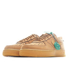 Pair of tan Nike low-top sneakers with teal heel tabs and lace eyelets