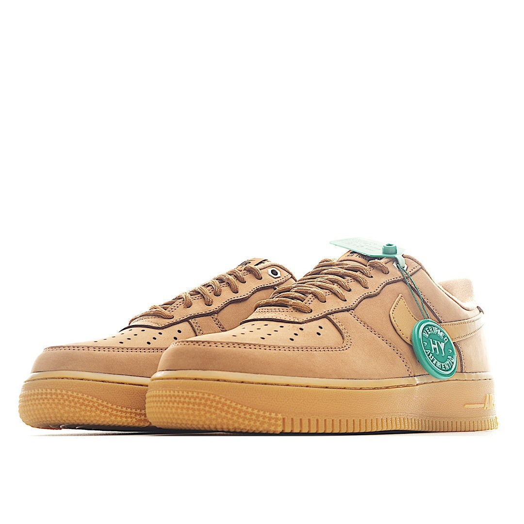 Pair of tan Nike low-top sneakers with teal heel tabs and lace eyelets