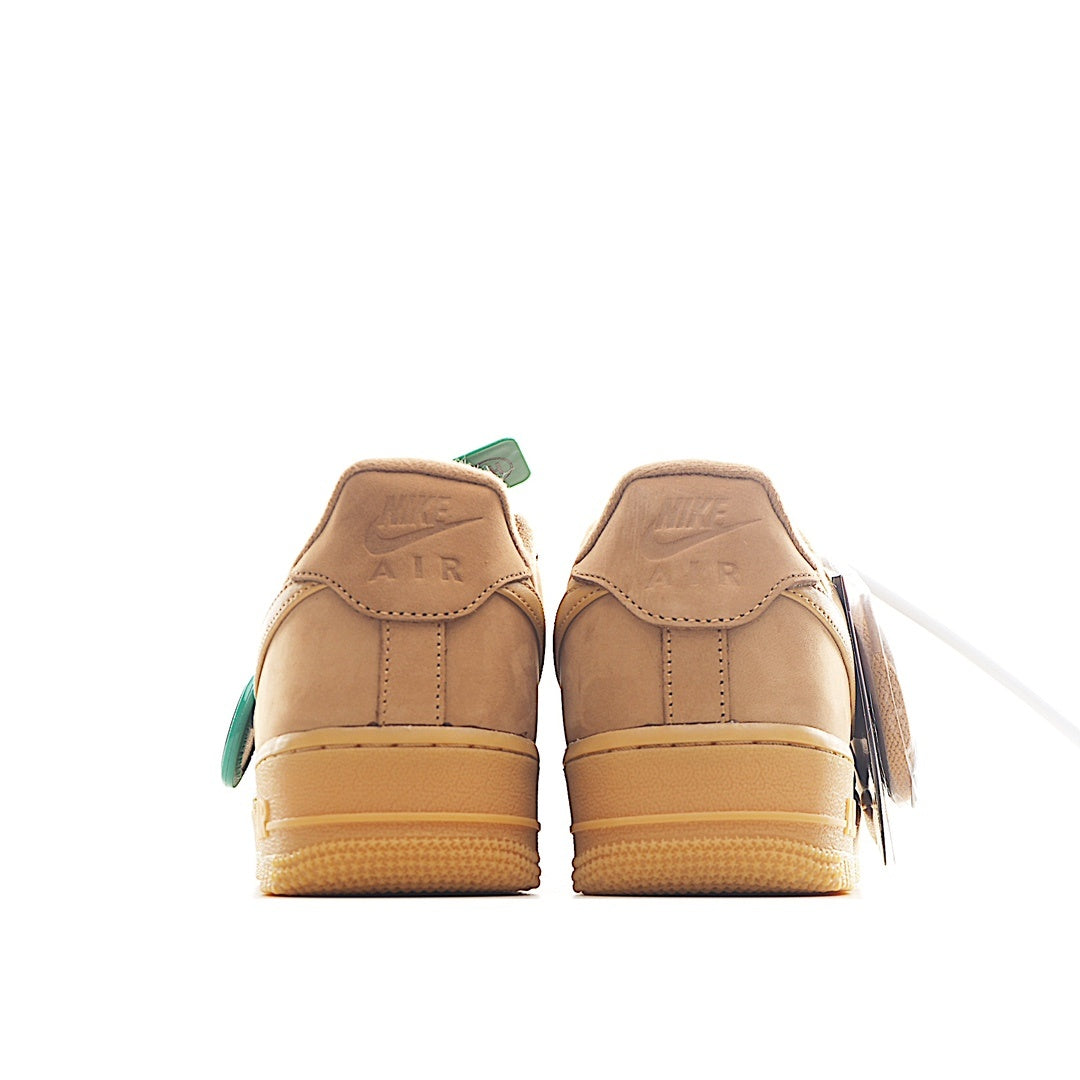 Back view of tan Nike low-top sneakers with teal heel tabs and AIR text
