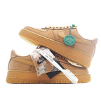 Tan Nike low-top sneakers with teal HY badge and gum sole