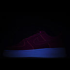 Dark low-top sneaker with blue sole and subtle purple upper detailing