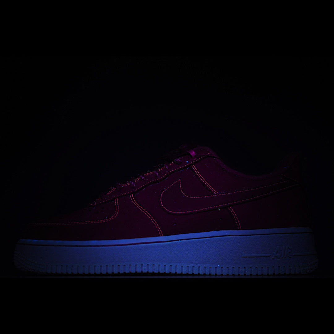 Dark low-top sneaker with blue sole and subtle purple upper detailing