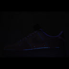 Dark low-top sneaker with faint blue glowing trim