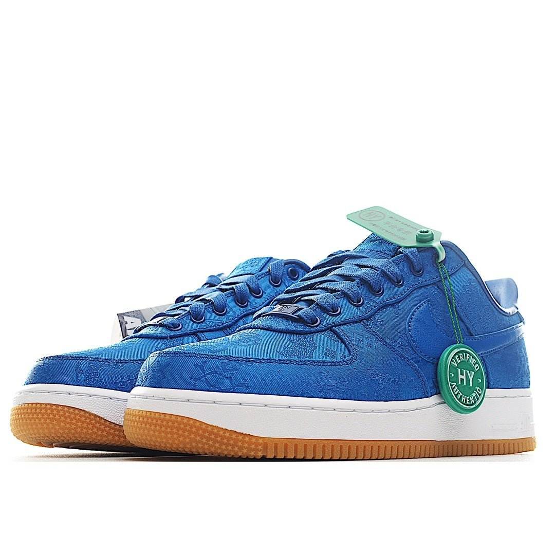 Blue Nike sneakers, side view, white midsole and gum outsole, with green HY tag.