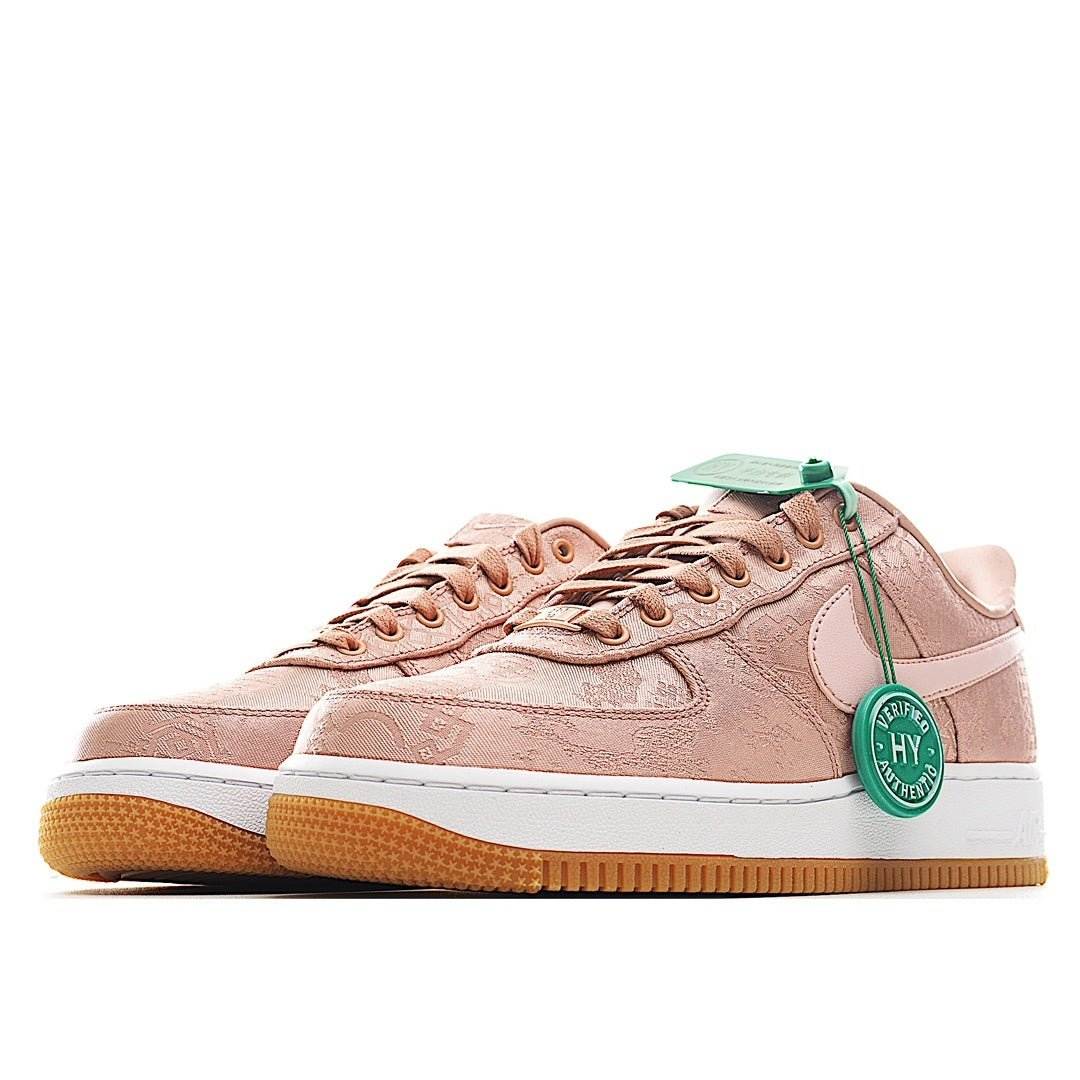 Rose pink low-top sneakers with lace-up front, white swoosh, gum sole, green tag.