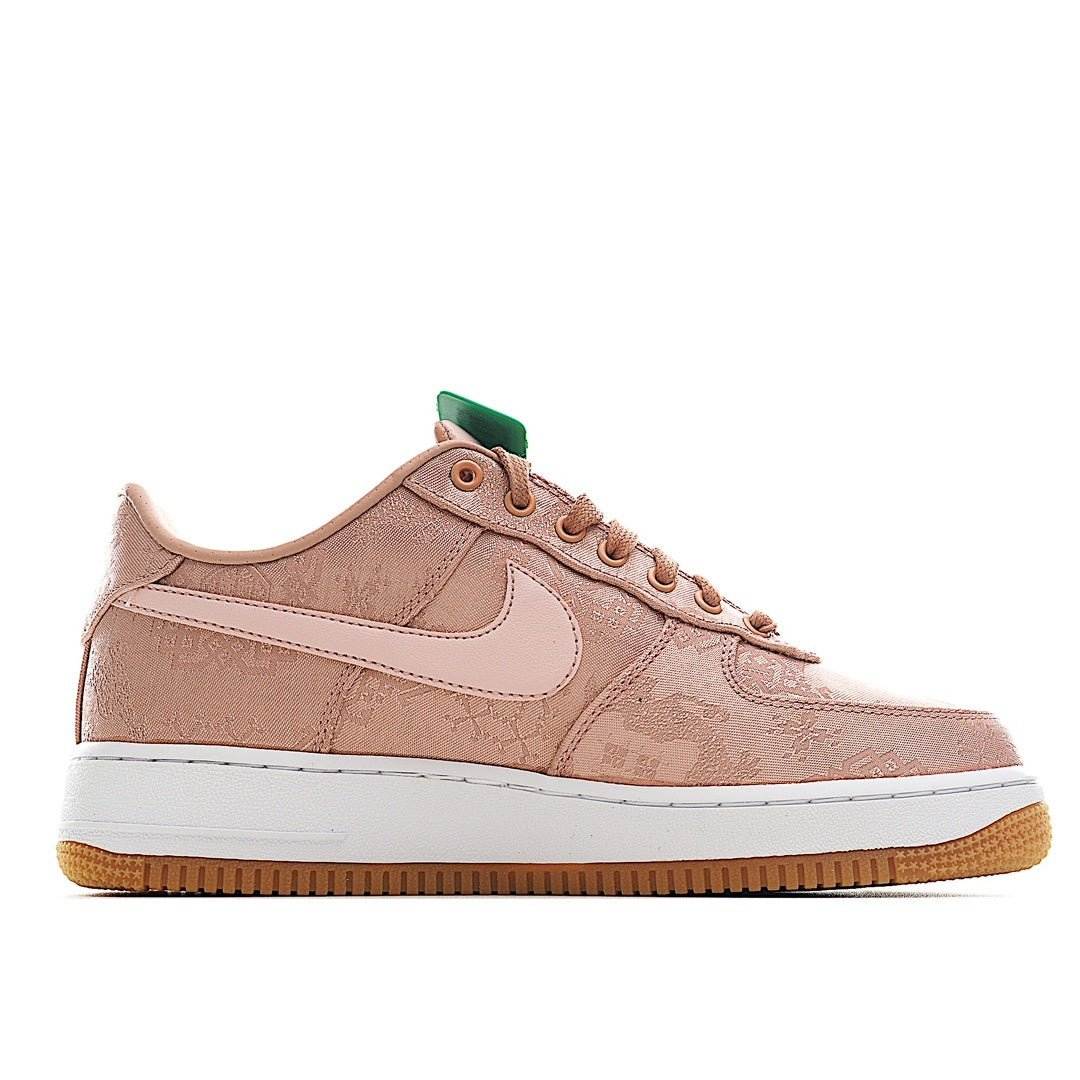 Rose pink Nike low-top sneakers, white swoosh side, tan laces, white midsole.
