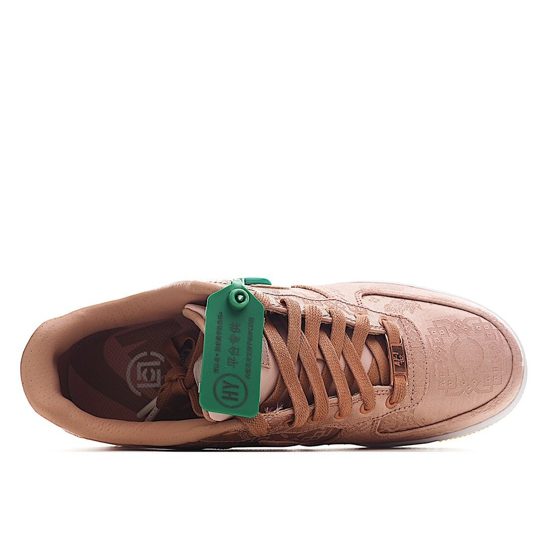 Pink Nike Air Force 1 low-top sneaker with green lace tag and brown laces