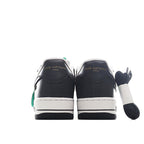 Black and white sneakers with green accents, rear view and white midsoles