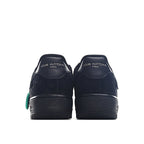 Black low-top sneaker heel view with branding and green pull tab