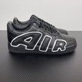 Black low-top sneakers with white flame-style logo overlays and black laces.